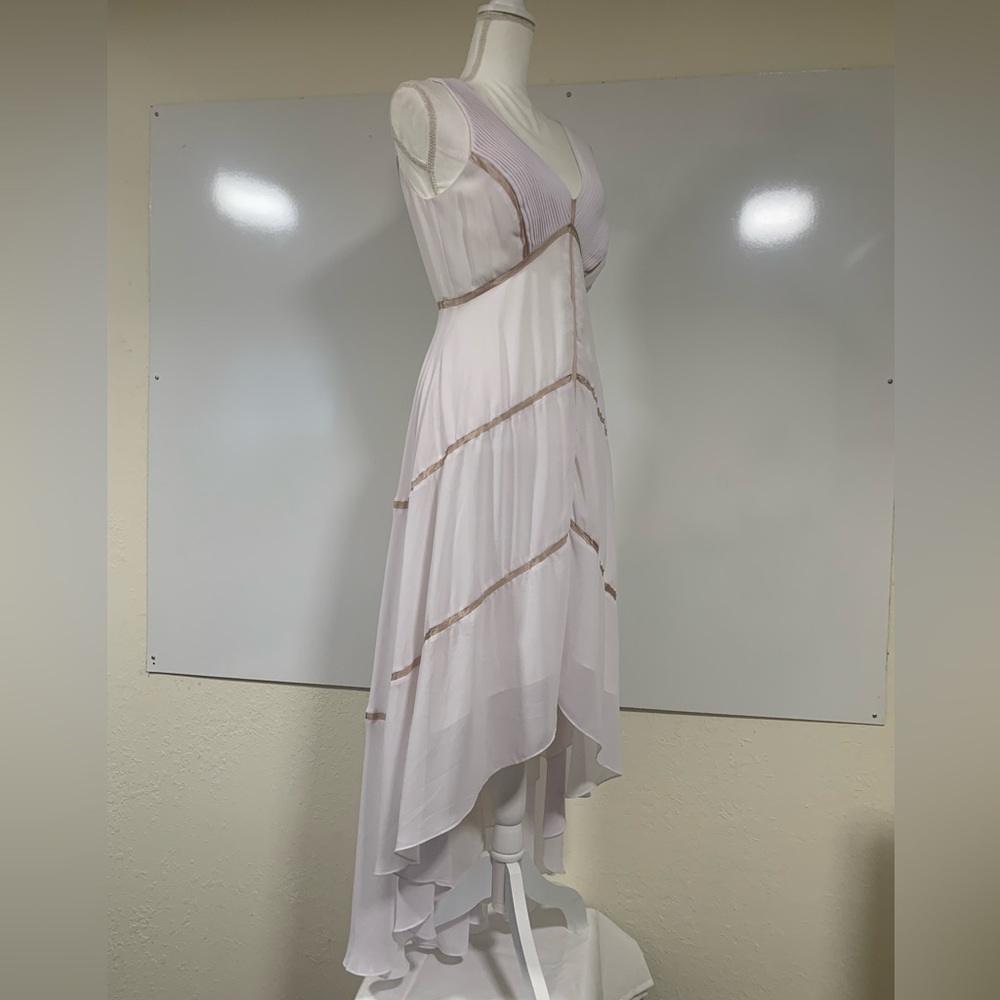 White asymmetrical hemline dress with pleated bodice area and ribbon detail